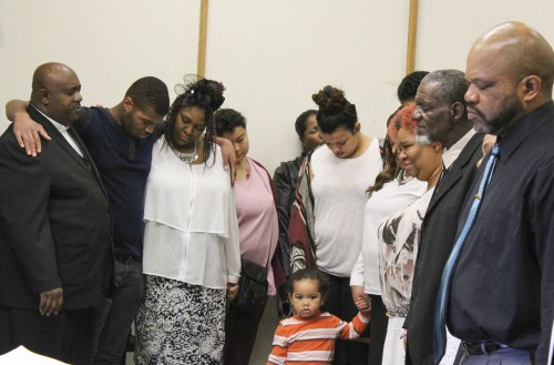 Faith Covenant Community Church’s pastor Kendall Young prays with members of the congregation while embracing one another. The church meets every Sunday at ARC in Raef Hall. (Photo by Timon Barkley)