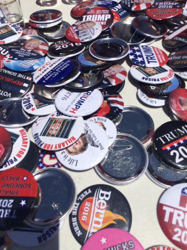 Nearly a dozen vendors set up along the entrance of the Trump rally in Sacramento, offering buttons, shirts, and the ubiquitous hats. (Photo by Justina Sharp)