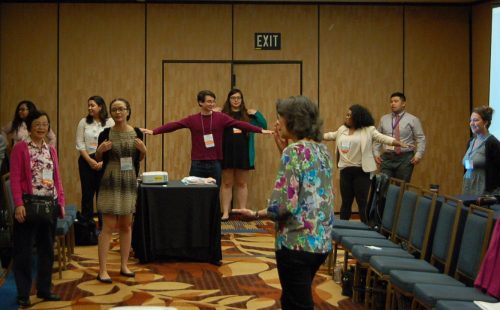 NCORE attendees at the "Mixed Asian Heritage" panel session, including current and former ARC students, participate in an exercise designed to connect their minds to their bodies on June 1, 2016. The session was one of more than 250 offered at the conference in San Francisco last week. (Photo by Hannah Darden)