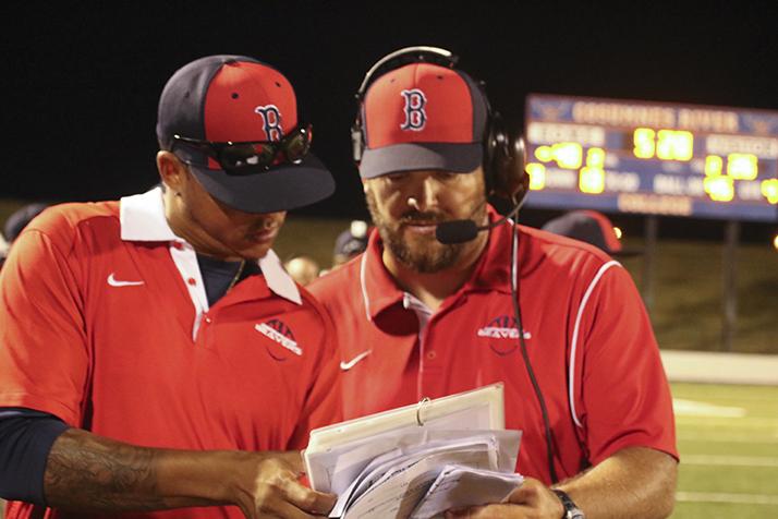 American River College wide recievers coach Michael Johnson and head coach Jon Osterhout look over the playbook on the sidelines during a game against Modesto Junior College on Sept. 10 at Cosumnes River College. ARC won 47-33. (Photo by Laodicea Broadway)