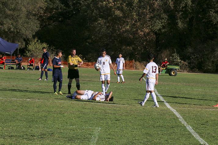 Hartnell College midfielder Patricio Nolasco lies on the field while other players talk with the referee during a soccer game against American River College on Sept. 20. ARC lost 4-0. (Photo by John Ennis)
