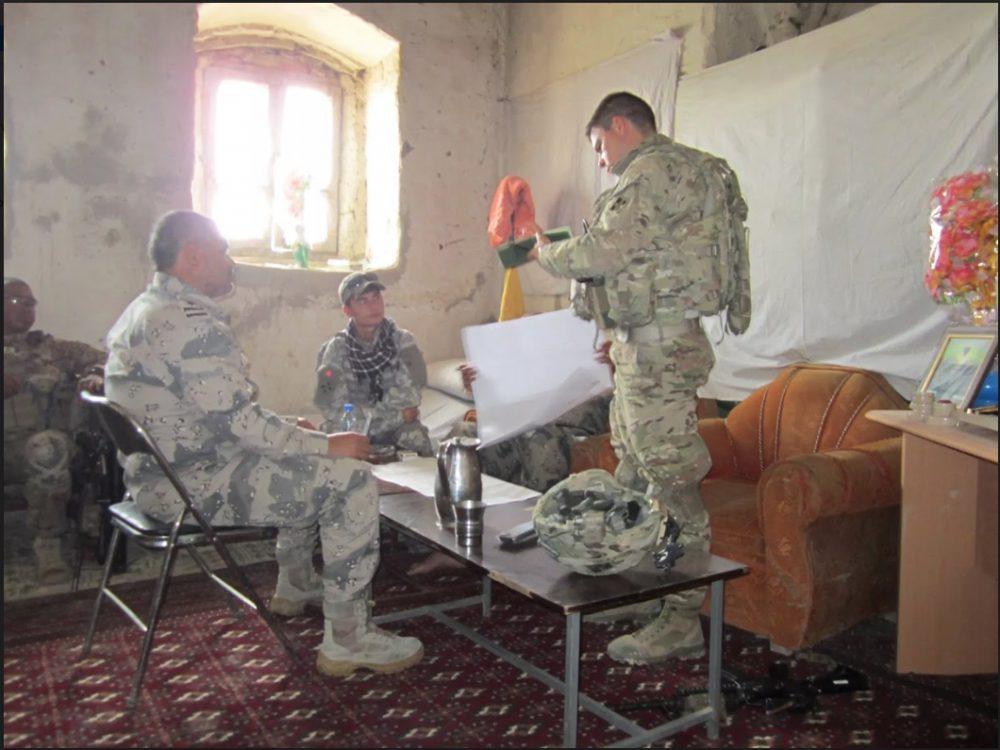 Qais Ahmad (center) translates for first lieutenant Noah Christen (right) from 4th ID troops and Colonel shams kareemi, Commander of Afghan border police (left) in Khogyani district of Nangarhar province. (courtesy of Qais Ahmad)