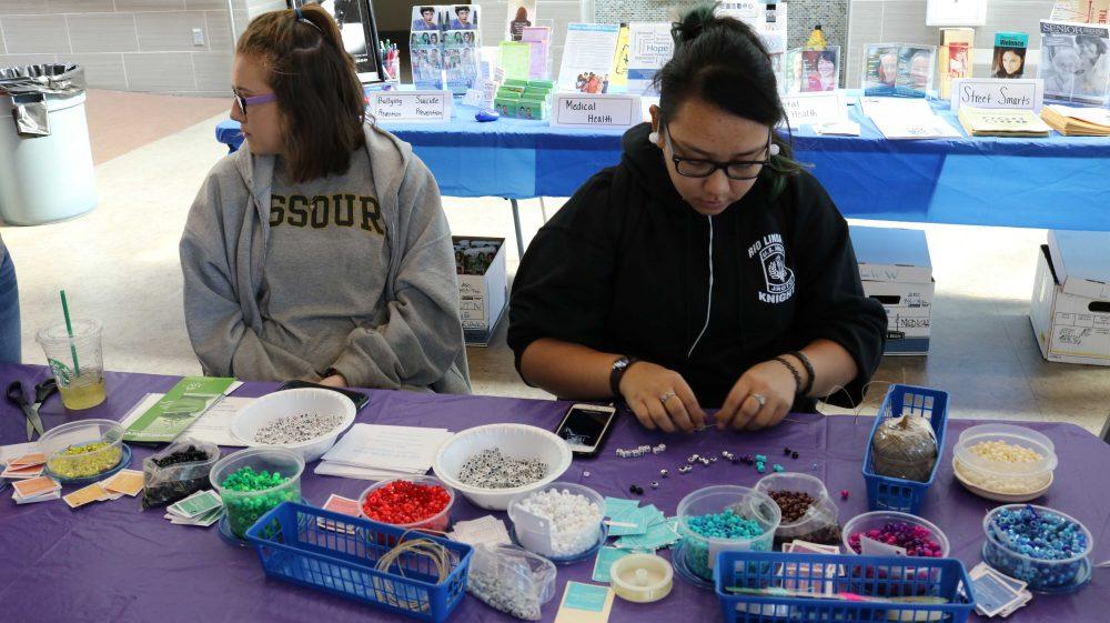American River College students support Life is Worth the Walk by making bracelets to support the wellness in the  Cafeteria on Oct. 20. (Photo by Cierra Quintana)