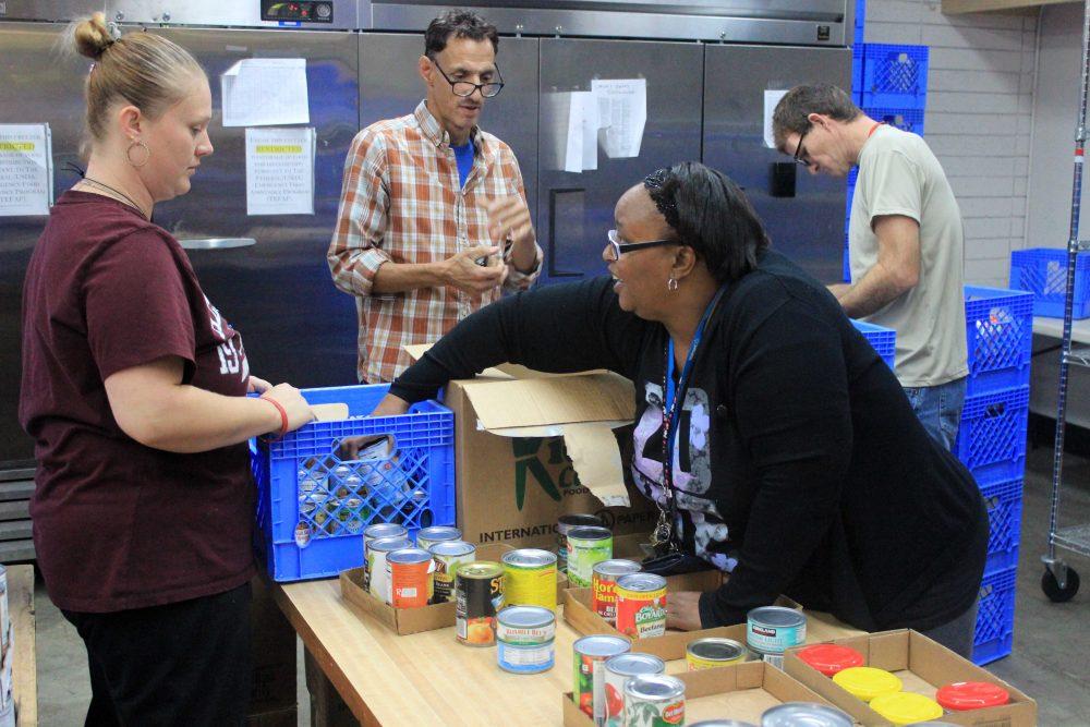 ARC student Peral Calhoun (front right) helps unload canned foods at the Carmichael Seventh-day Adventist Church food pantry, ahead of the holiday season rush. (Photo by Jordan Shcauberger)