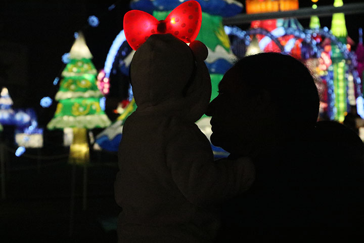 A woman looks at the child she is holding at Global Winter Wonderland at Cal Expo on Sunday in Sacramento, Calif. (Photo by Cheyenne Drury)