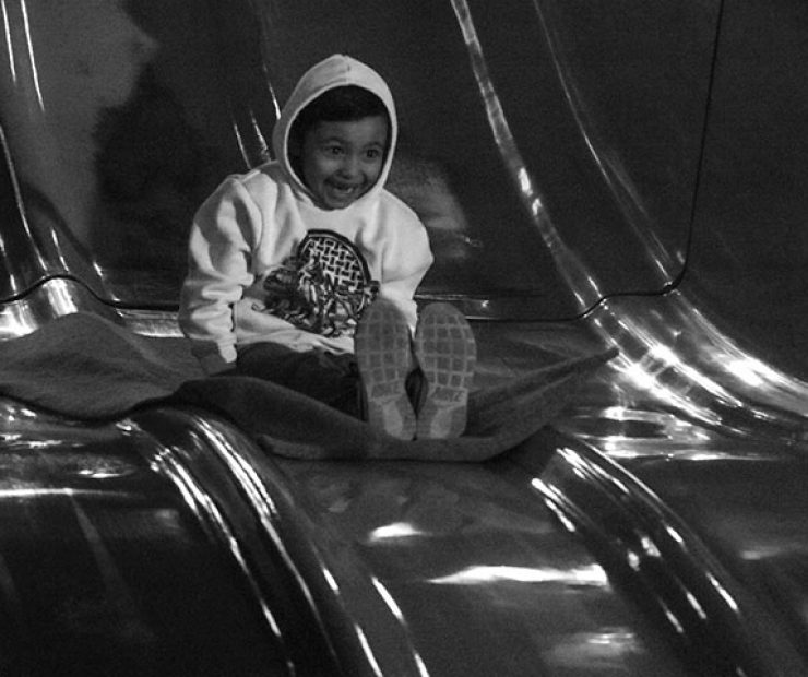 A boy goes down a slide at “Global Winter Wonderland” at Cal Expo on Sunday in Sacramento, Calif. (Photo by Cheyenne Drury)