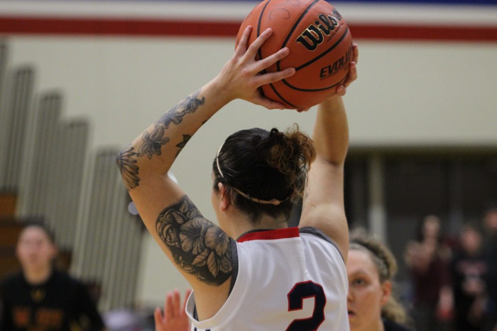 ARC guard position Rauline Martinez holds the ball over her head to pass to a teamate. (photo gallery by Lidiya Grib)