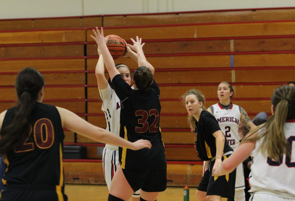 ARC sophomore forward Benjiu Atik holds ball above her head and comes face to face with Sacramento City freshman forward, Meghan Case. ARC Womens Basketball defeated SCC 70-56 on Thursday. (Photo by Lidiya Grib)