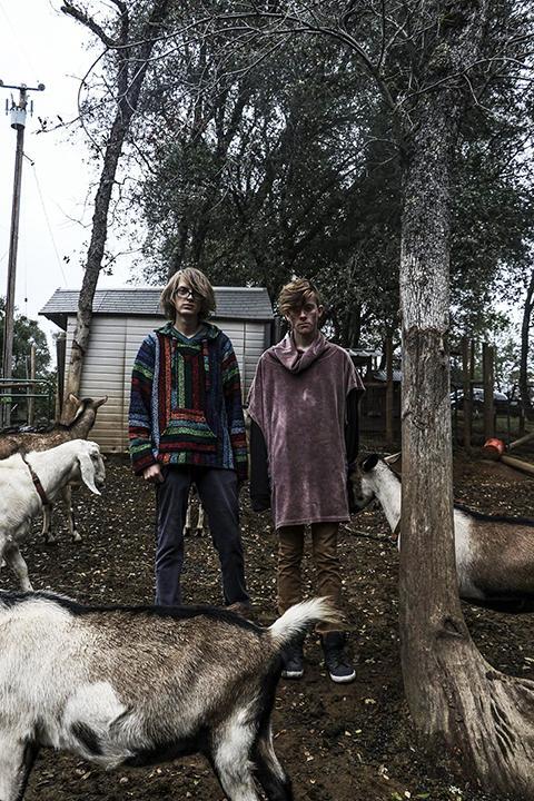 Justin Carter (left) and Bryce Mondul stand inside the goat enclosure at Georgio Klironomos' ranch in Placerville, California on Oct. 27, 2016. (Photo by Luis Gael Jimenez)