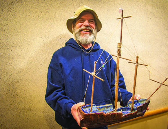 Tom Roberts holds up a ceramic boat that he made at American River College. Roberts survived a traumatic brain injury in 1978. He has been enrolled at ARC every semester since 1989. He passed away on Oct. 22, 2016 of cancer. (Photo by Luis Gael Jimenez)