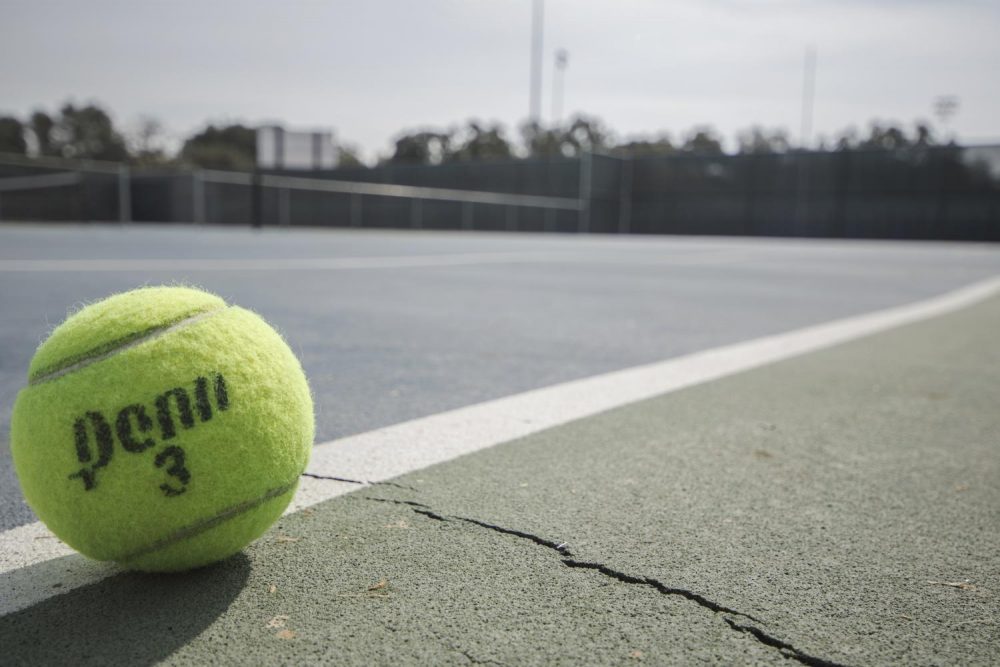 A tennis ball sits on the cracked ground of the American River College tennis courts. The courts are so badly cracked that many of them are unusable. (Photo by Brienna Edwards)