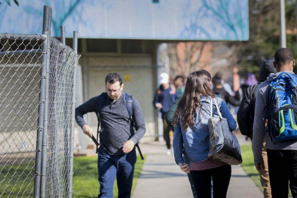 American River College students walk by the fenced-off Liberal Arts building on Feb. 7 in Sacramento, California. The Liberal Arts building at American River College will be torn down and be replace with the new S.T.E.M building.(Photo by Ashley Hayes-Stone)