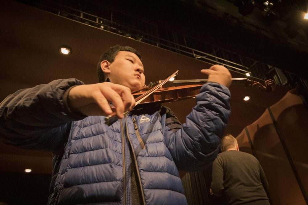 Anthony Zhao plays the lead violin during the rehearsal on Mar. 8 at American River College. (Photo by Ashley Hayes-Stone)