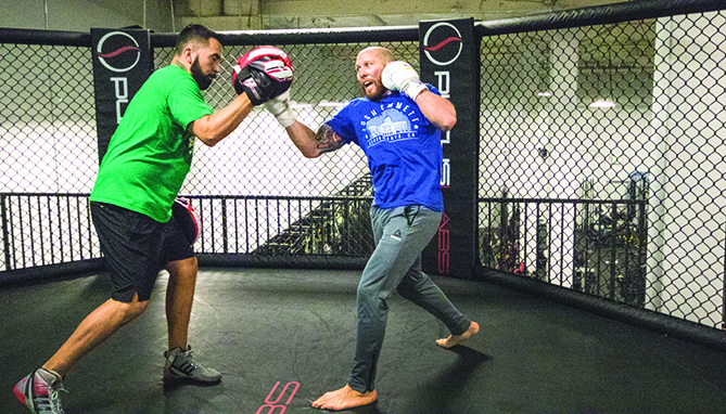 UFC fighter Josh Emmett trains in the octagon with his trainer Joey Rodriguez at on Feb. 14 at Urijah Fabers Ultimate Fitness. Emmett is preparing for his first UFC main event fight against Jeremy Stephens on Feb. 24 in Orlando, FL. (Photo by Ashley Hayes-Stone)