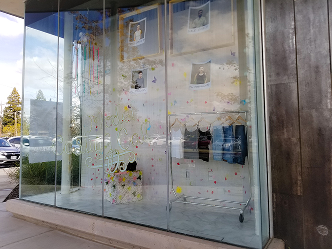 Clothes and photos hang in a display outside of the Science and Fine Arts Building for the Fashion Show Model Casting on March 16. (Photo by Hannah Yates)