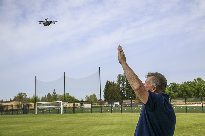 Shane Lipscomb lifts his hand to the sky in an effort to lock in to the drones smart capture, where the drone will follow hand signals, to get it to land without a remote. April 4, 2018. (Photo by Brienna Edwards)