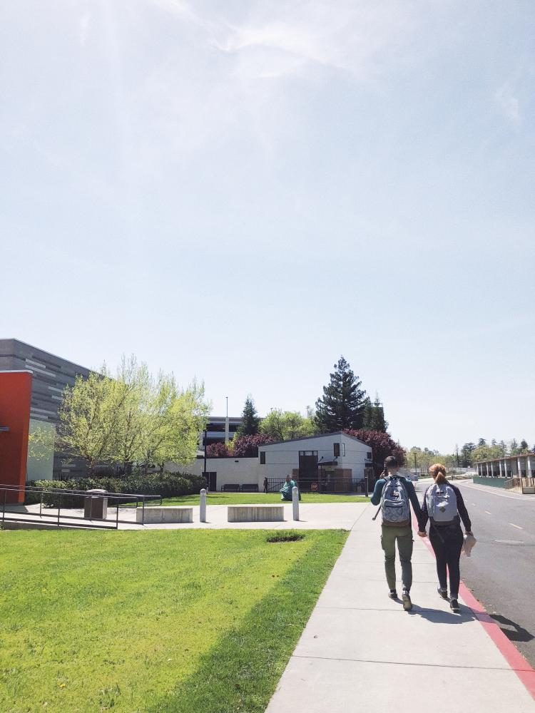 Students hold hands as they walk around campus at American River College on April 20, 2018. (photo by Alondra Botello)