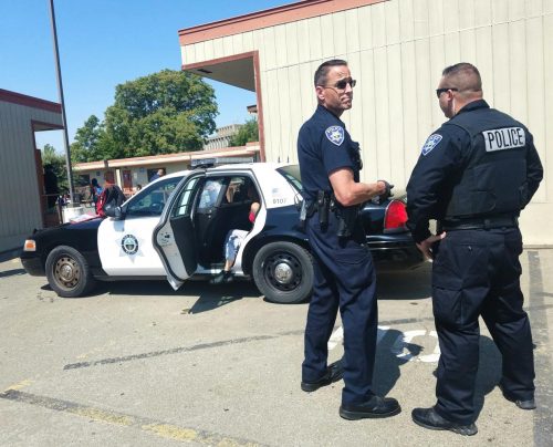 Los Rios Community College officer Joe Quirarte and a fellow officer detain two suspects of a potential altercation at American River College on Aug. 27, 2019. (File Photo)