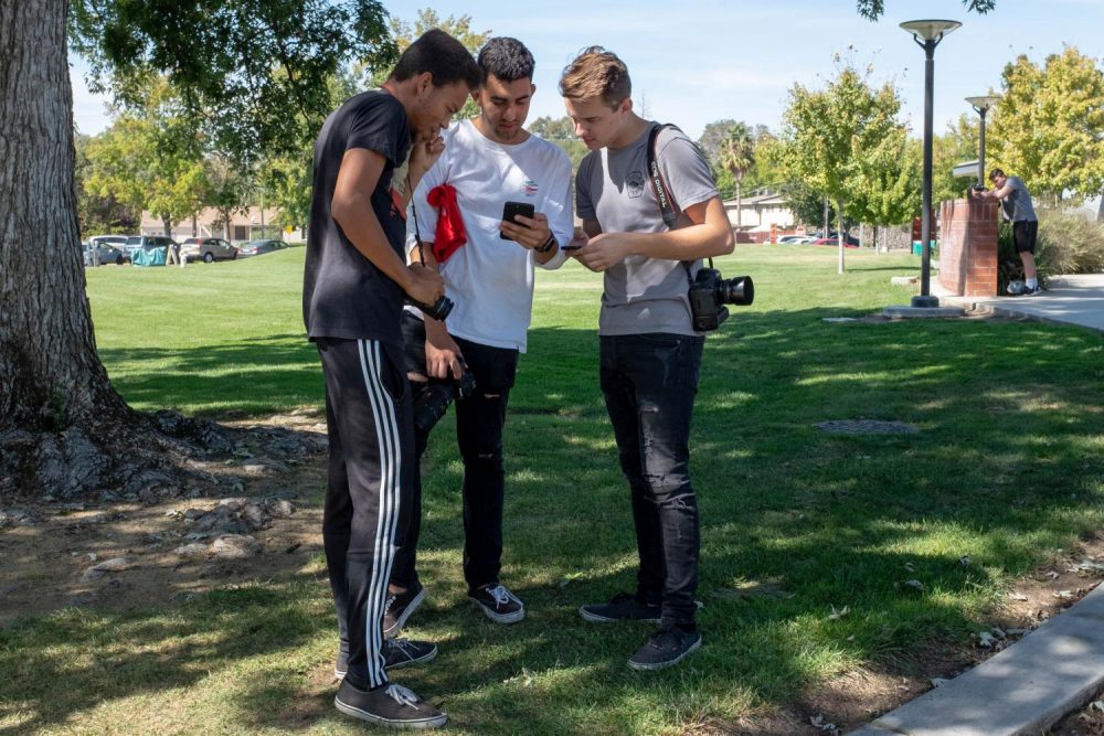 Students in Art Photography 305 (from left to right) Ryan White who studies education, Roberto Salinas, biology major, and Alex Chmil, computer science major, practice using their cameras in the field by American River College’s theatre on Sept. 27. (Photo by Patrick Hyun Wilson)