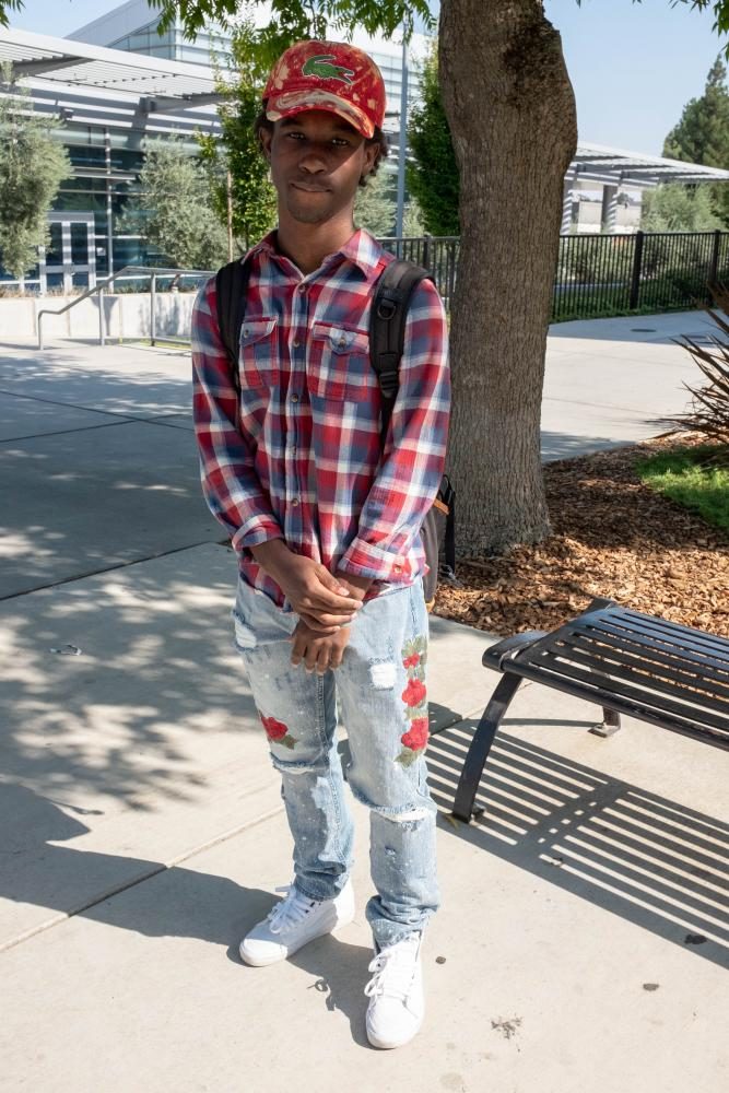 Computer Engineering major, Devontae Robinson wears a checkered flannel shirt in American River College colors and jeans with embroidered roses on each leg at ARC on Sept. 4.
You dont have to wear designer to be stylish. People wear $4,300 Gucci shoes or $1,000 shirts and thats so called style, Robinson said. (Photo by Patrick Hyun Wilson)