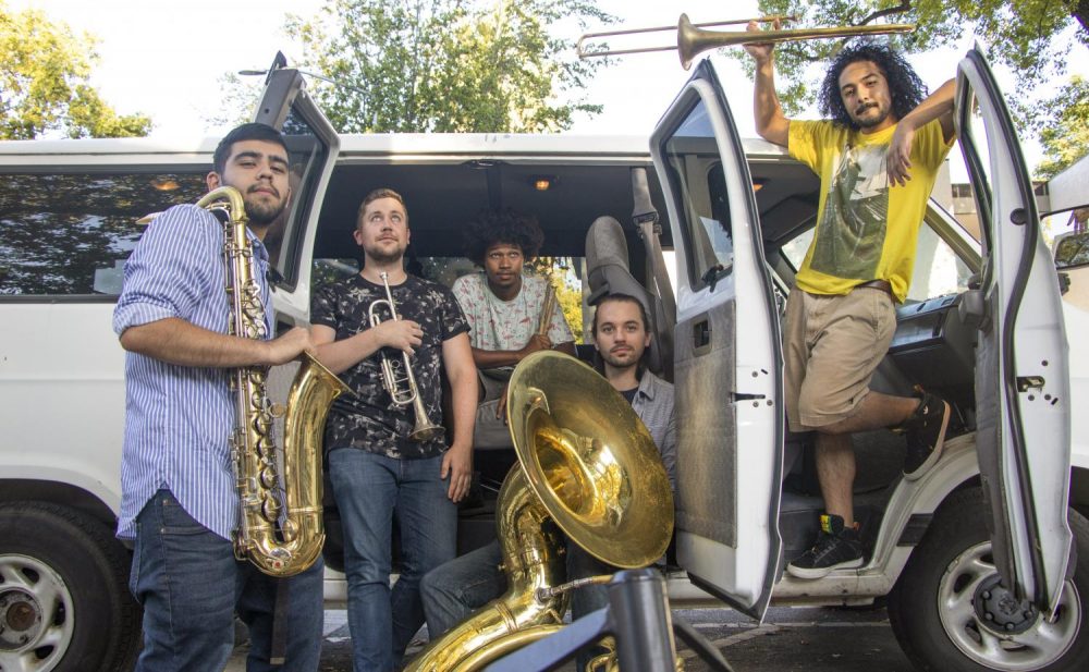 City of Trees Brass Band members Isaac Negrete, Matt Voller, Devon Edmond, Ben Hillier and Miguel Recendez pose in front of their van named “Ashley” in front of Der Biergarten in Sacramento, on Sept. 6, 2018. (Photo by Ashley Hayes-Stone)