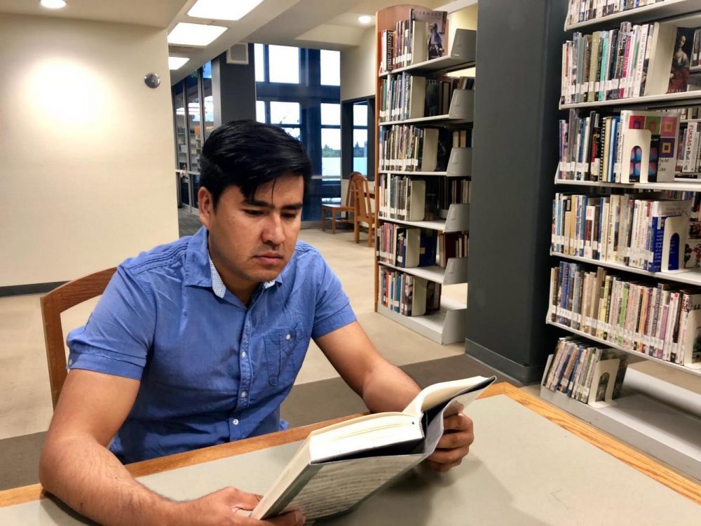 Mohammad Ewaz Wafai, political science major and former interpreter for the U.S. Army reads in the library at American River College on Oct. 3, 2018. (Photo by Hameed Zargry)