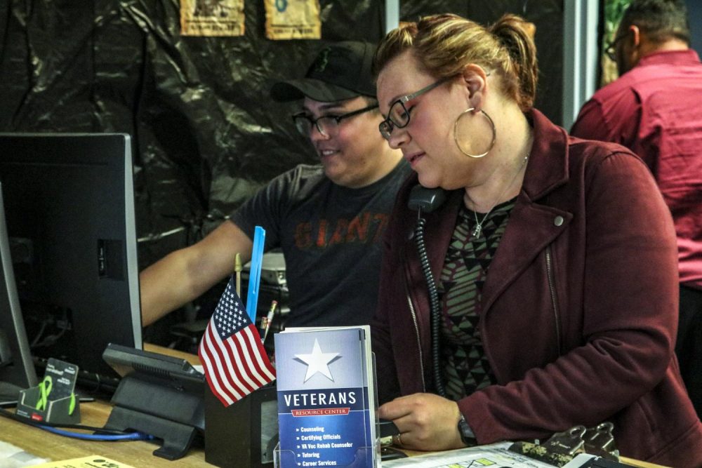 Nicole Williams (right) the Trio Veterans Program advisor answers the phone while computer science major Spencer Barns works on the computer in the Veterans Resource Center on Oct. 24, 2018 at American River College. (Photo by Tracy Holmes)