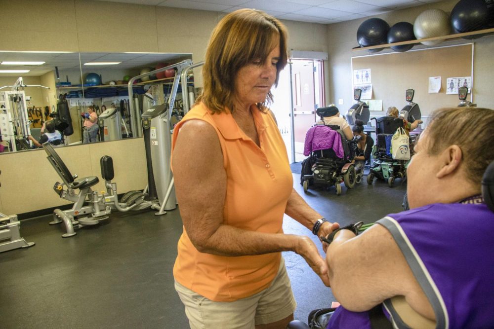 Professor Raye Maero assists computer science major Allison Murdaugh with seated row exercises during an adapted weight class in the at American River College  on Oct. 8, 2018. (Photo by Christian Sutton)