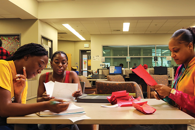 Umoja Sakhu club members Raqhale Brooks, (left) pre-law major, Nyla Aaron, (center) undecided major and Grace Swint, (right) political science and sociology major study in the Hub Center at American River College on Oct 15, 2018. (Photo by Breawna Maynard)