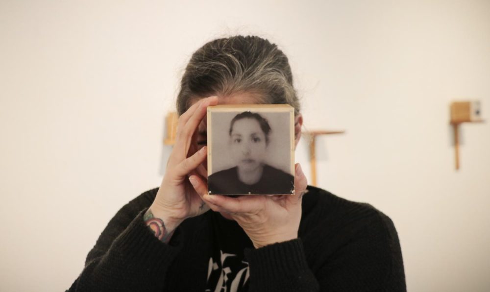 Photographer Angela Casagrande displays her exhibition, “Everything will Disappear,” at the James Kaneko Gallery at American River College on Nov. 28, 2018. Casagrande holds up a box with a picture of her on it. The box contains pieces of her hair because she said making these boxes caused her a lot of stress and made her lose hair. “Everything will Disappear” will run at the Kaneko Gallery until Dec. 14. (Photo by Gabe Carlos)
