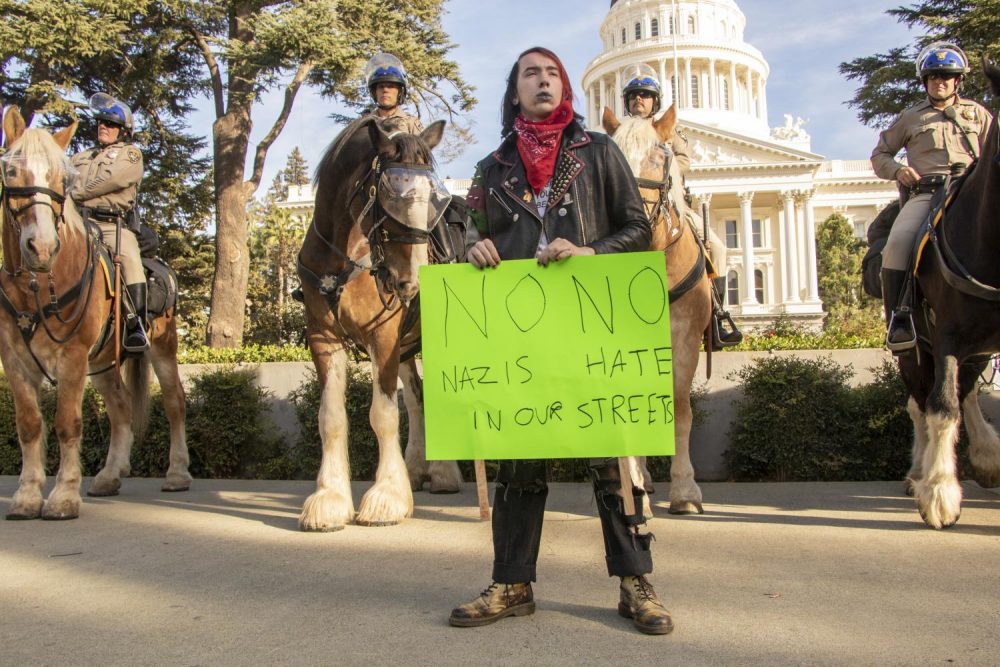 Counter protester Jules Miller holds up a sign that reads “No Nazi No Hate in Our Streets” during a  “Turn California Red” conservative rally at the California State Capitol in Sacramento on Nov. 4, 2018. (Photo by Ashley Hayes-Stone)