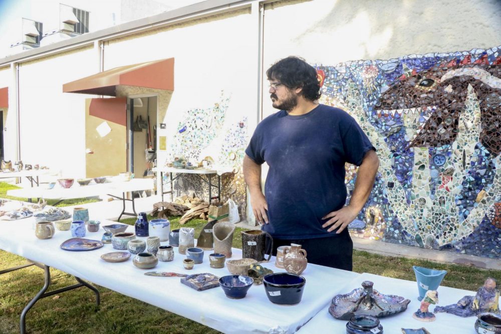 Alex Wash is an art major, selling ceramics to raise funds for the program, scholarships and equipment. A section of the sale has bowls decorated with cat themes to raise funds to feed orphaned cats on campus, organized in collaboration with ceramic professor Linda Gelfman and Theatre professor Nancy Sylva. The ceramics sale is held once during the last week of the semester at American River College. (Photo by Itzin Alpizar).