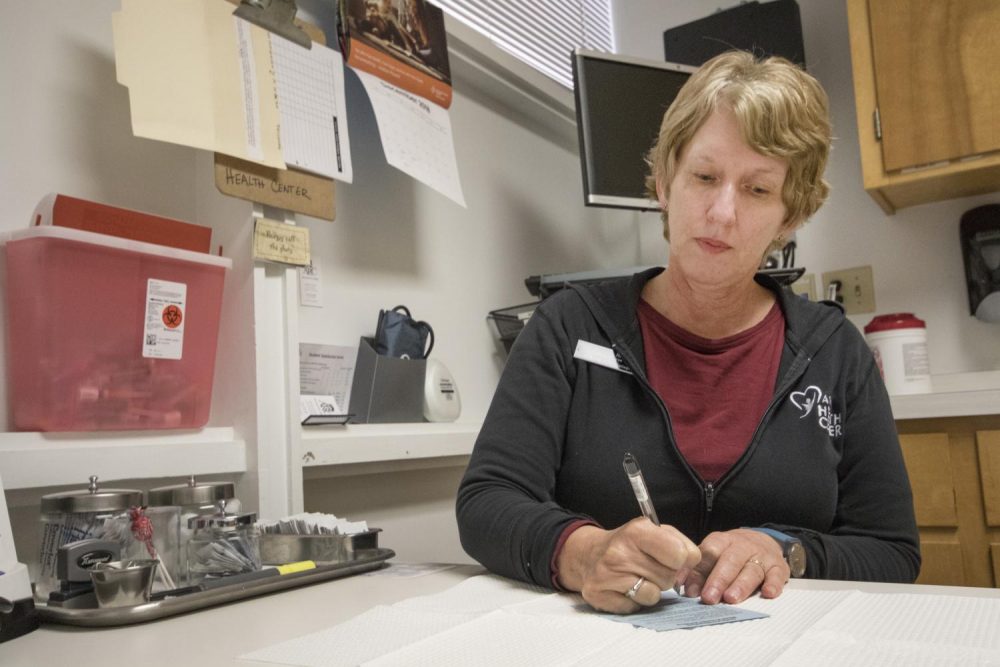 Nurse Pam Whipple writes notes after student appointments in one of the consultation rooms in the Health Center at American River College on Dec. 10, 2018. (Photo illustration by Ashley Hayes-Stone)