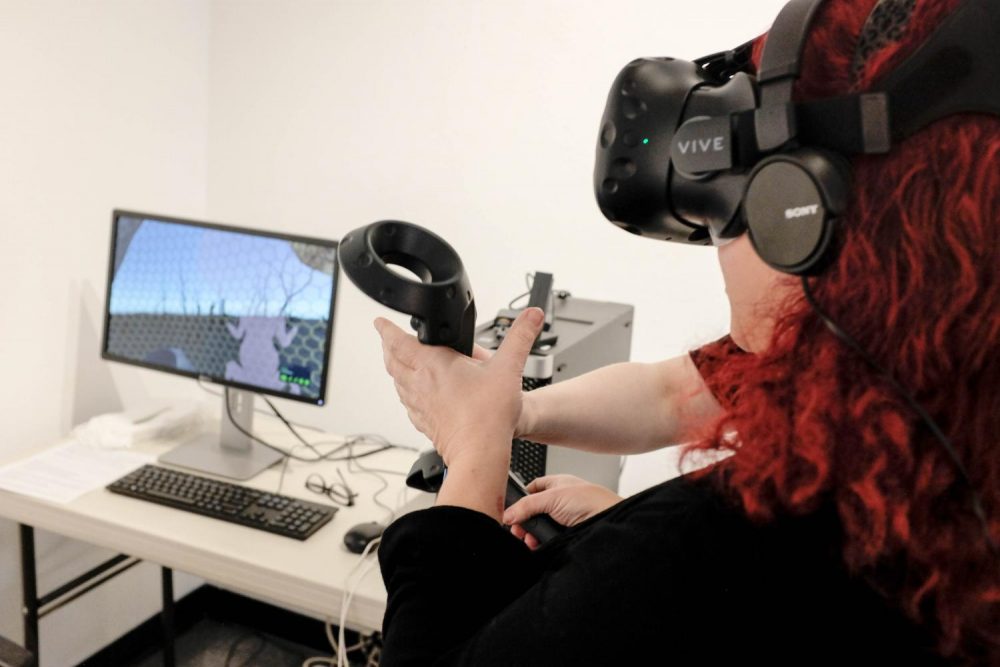 James Kaneko Gallery intern Frankie Vanity demonstrates the virtual reality segment of the current exhibition Ecotones. The exhibition is an installation by Rachel Clarke, at James Kaneko Gallery from Jan. 22 until Feb. 12, 2019. (Photo by Patrick Hyun Wilson)