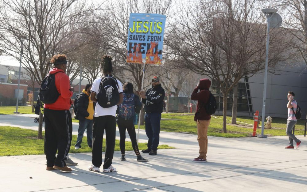 A self declared “Preacher of God” protests and holds a protest sign that reads “Jesus Saves From Hell” in front of the Student Center at American River College on Jan. 30, 2019. ARCs Public Information Officer Scott Crow addressed the situation in an email. As a public institution, American River College has a responsibility to provide a space for constitutionally protected free speech, irrespective of the beliefs expressed in that speech, he wrote. We also have an obligation to encourage a civil dialogue about controversial issues.  Crow advised anyone who is negatively impacted to the reach out to the Counseling Center or the HUB for support. (Photo by Hameed Zargry)