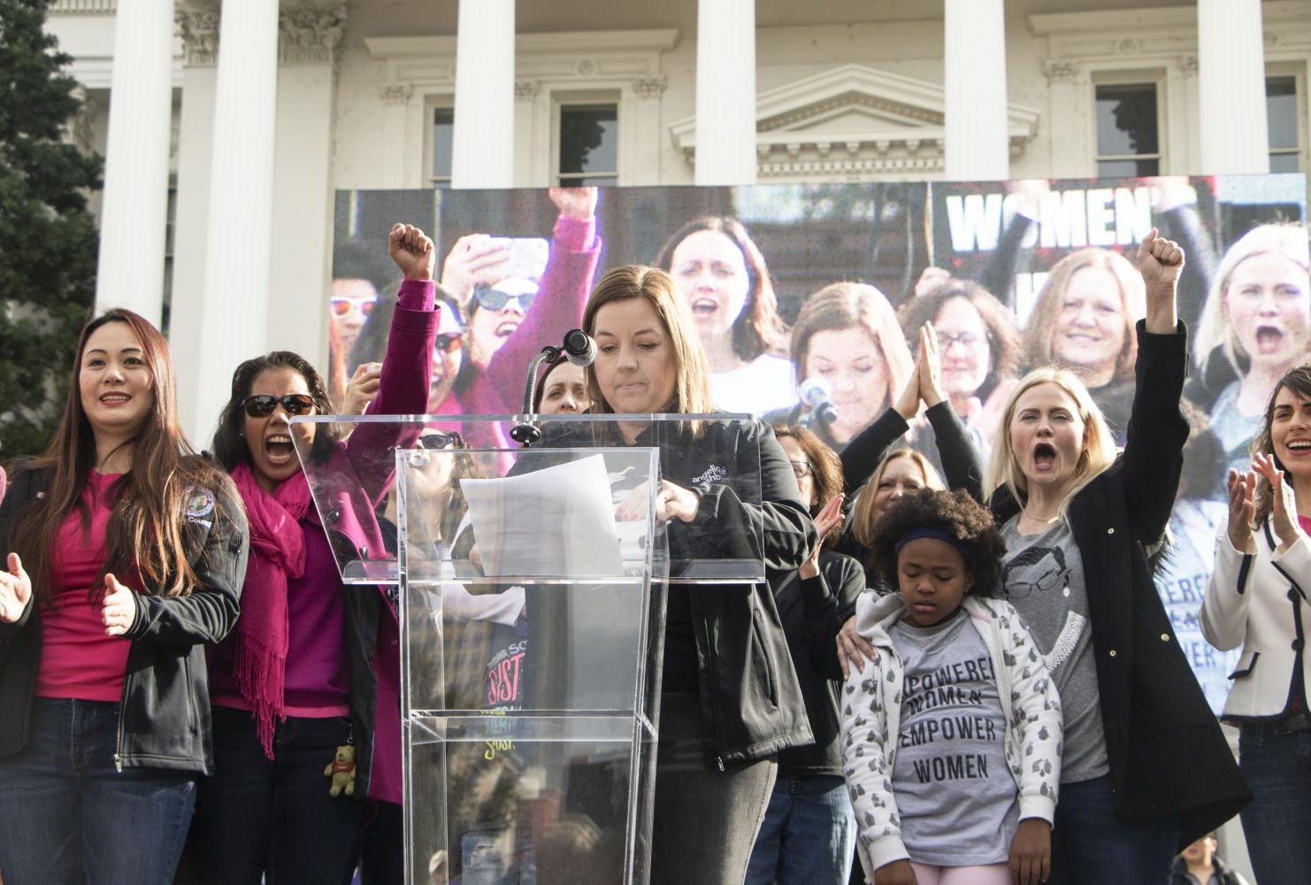 Sacramento councilwoman Angelique Ashby reads off the names of women who were recently elected to boards and councils in the Sacramento area while some of whom joined her on stage at the steps of the California State Capitol during the third annual Sacramento Women’s March on Jan. 19, 2019.