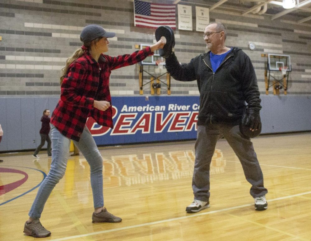 Clint LeMay, assistant to the head instructor, runs drills with mits for dental hygiene major Yelena Vovk during the Personal Safety class in the fitness department at American River College on Feb. 12, 2019. (Photo by Alexis Warren)