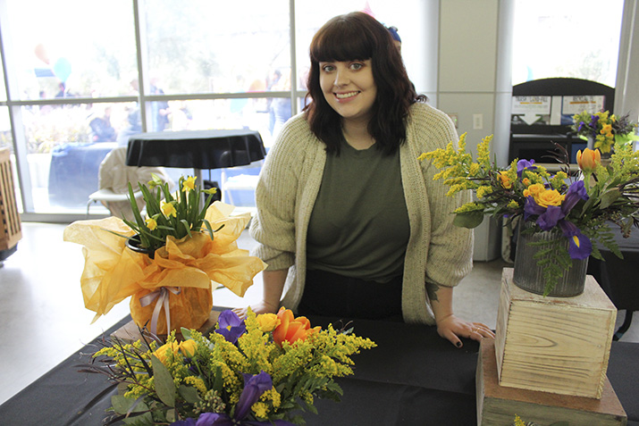 Christen Hollingsworth, an intern with the floriculture department, sells floral arrangements at the Horticulture Floral Sale on Feb. 7, 2019. (Photo by Ariel Caspar)