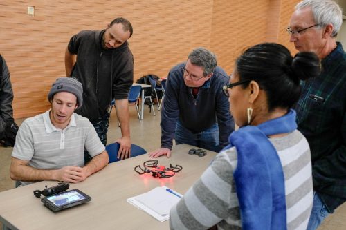 Students of the drone class, Experimental Offering in Design Technology, gather around Sean Franklin (left), who describes the various operations that are available in the drone unit they were flying in the Student Center at American River College on Feb. 2, 2019.