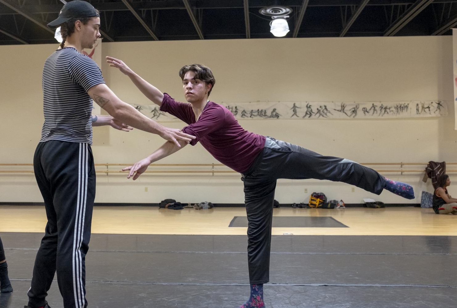 Is Foss assists fellow dance student José-Antonio Gomez as he practices his form during his warm-up in Dance Production: Studio and Stage class at American River College, on Feb. 6, 2019. Gomez is a firstyear student in the dance program. (Photo by Patrick Hyun Wilson)