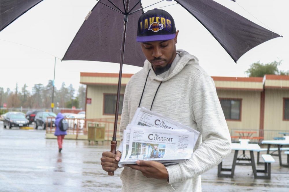 Staff writer Anthony Barnes holds the newest copy of the American River Current during distribution at American River College on Feb. 13, 2019. (Photo by Thomas Cathey)