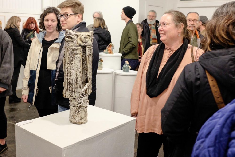 Photography professor Jodie Hooker admires the works of art made by her colegues during the opening reception for the ARC Faculty/Staff Art Show at the E Street Gallery on Feb. 10, 2019. (Photo by Patrick Hyun Wilson)