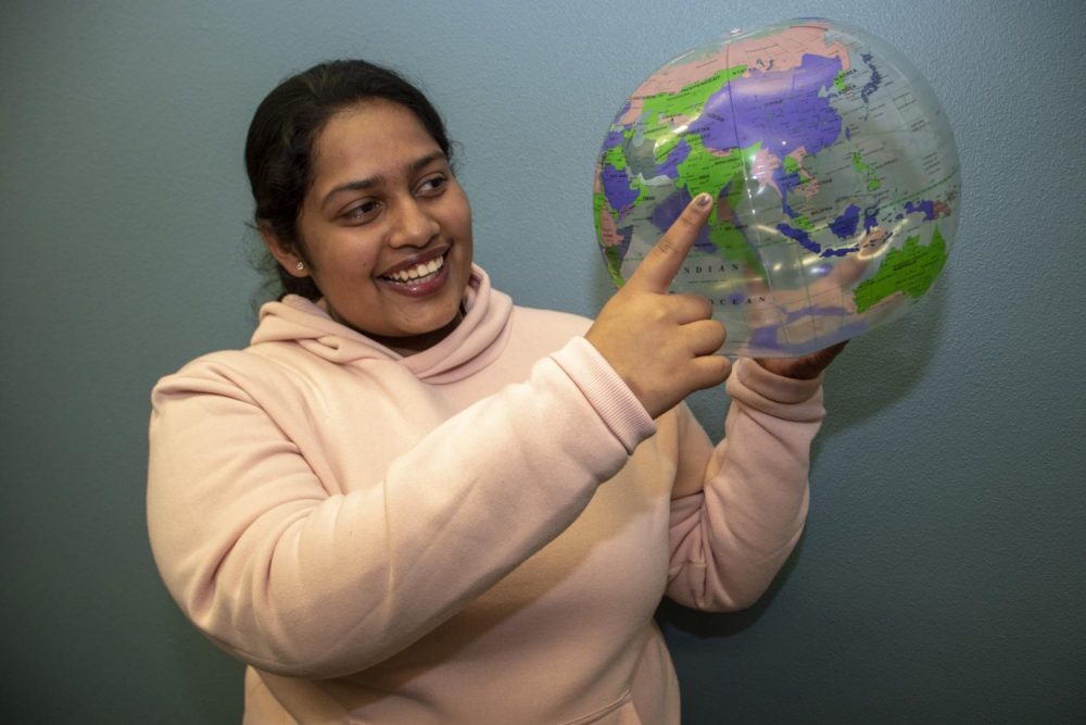 International student and business major Christina Abraham holds up a globe and points to India, where she’s from, during an international student meetup at American River College on Jan. 31, 2019. (Photo by Ashley Hayes-Stone) 