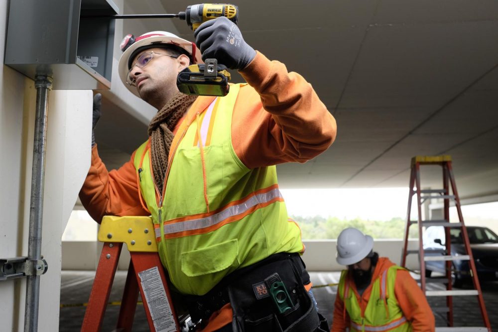 Electricians Billy Johnson and Derrick Camero install security cameras on the fourth floor of the parking garage at American River College on April 4, 2019. (Photo by Patrick Hyun Wilson)