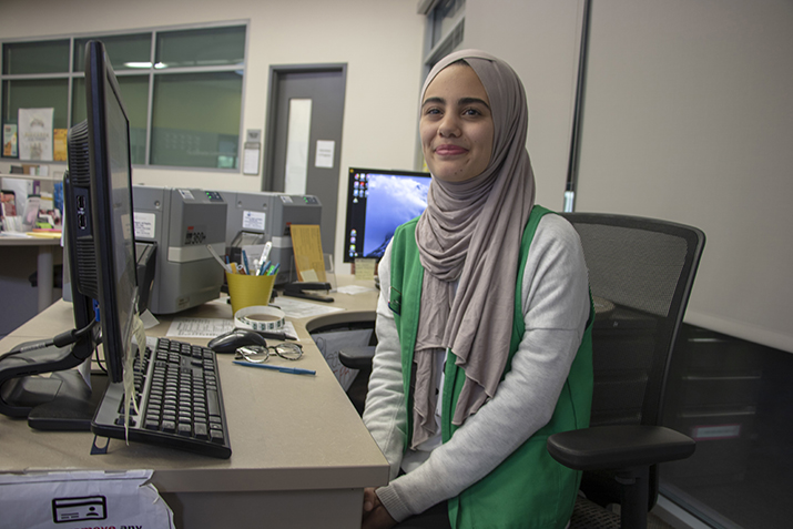 Aesha Abduljabbar answers questions about student ID cards while working as a SAGE student ambassador in the Center for Leadership and Development at American River College on April 30, 2019. Abduljabbar was recently elected the first Muslim woman Associated Student Body Student Senate President at ARC. (Photo by Hameed Zargry)