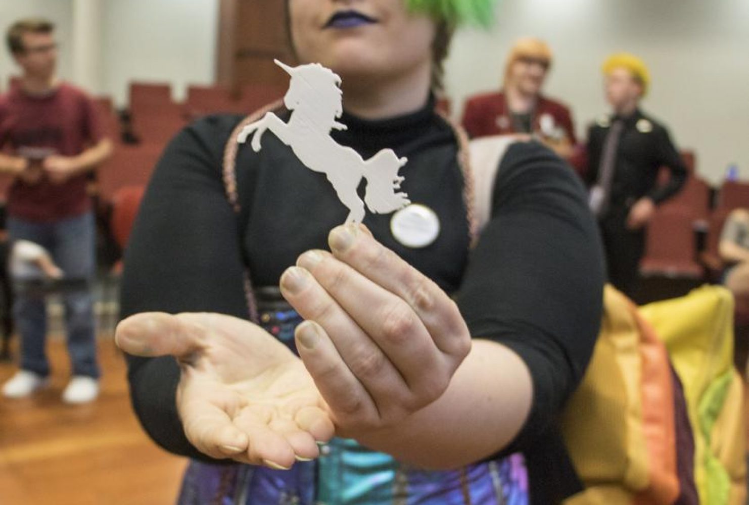 Graduate Jareth Ryford shows off their unicorn pin, 3-D printed for the event by the Design Hub, on May 3, 2019. (Photo by Ashley Hayes-Stone)