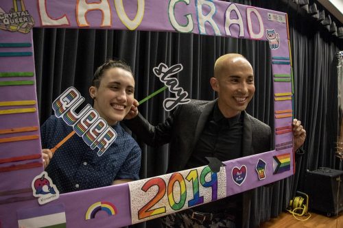 Pride Center student mentor Tori Miller and Equity Programs and Pathways Dean Joshua Moon Johnson pose with a prop frame at the ceremony on May 3, 2019. (Photo by Ashley Hayes-Stone)