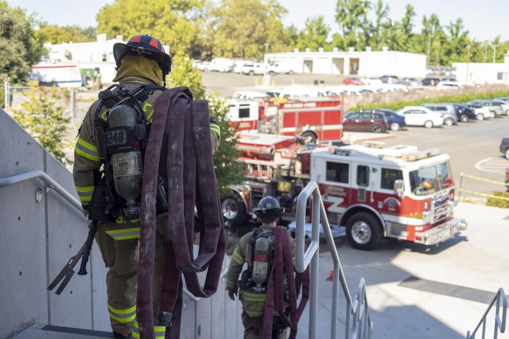 Firefighters Jake Bartlett and Gabriel Gomez carry fire hoses down from the top level of the American River College parking structure on Sept. 17, 2019. Sacramento Metro Fire District engines 24 and 103 ran drills testing the structure’s standpipe water system, which they would use in the event of a fire within the parking garage. (Photo by Jennah Booth)