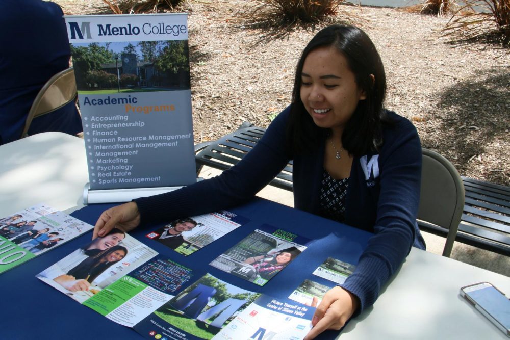 Justine Fiesta, a representative from Menlo College, goes over a flyer for the school on Sept. 20, 2019, much like schools will on Transfer Day this Wednesday. (Photo by Jack Harris)