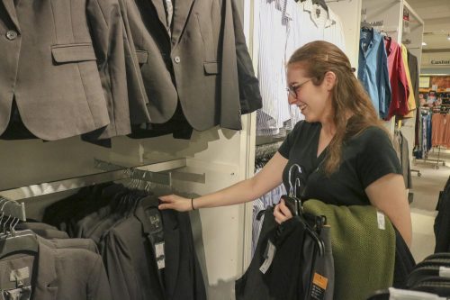 Sign language interpreting major and speech language pathology assistant Marissa Lang looks at blazers at the Suit Up event in JCPenney at Arden Fair Mall on Sept. 22, 2019. (Photo by Alexis Warren)
